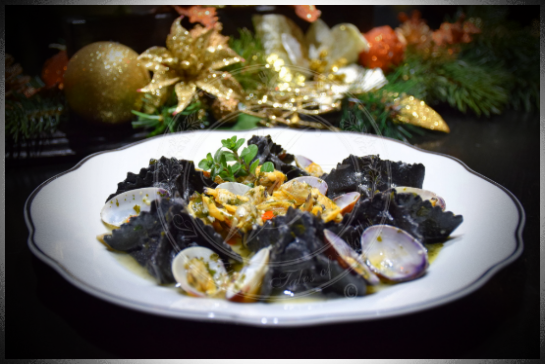 Ravioli al nero di seppia ripieni di mazzancolle e zucchine con soutè di vongole veraci